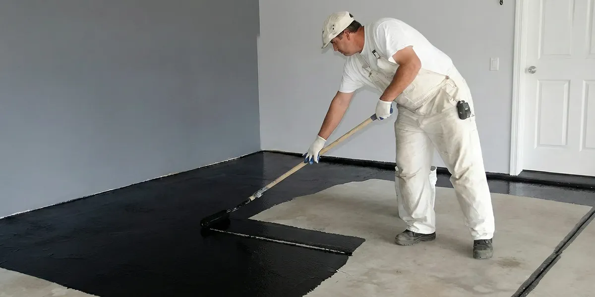 basement waterproofing professional applying waterproof coating to protect a basement floor in Bradenton, FL